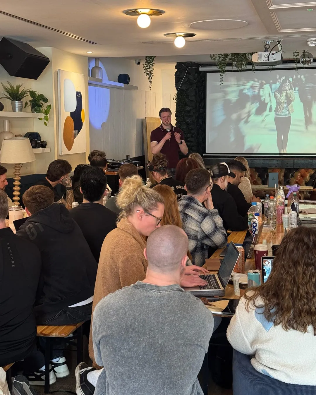 Nathan speaking to a packed room at The Amplifier in London, seen from the back of the audience