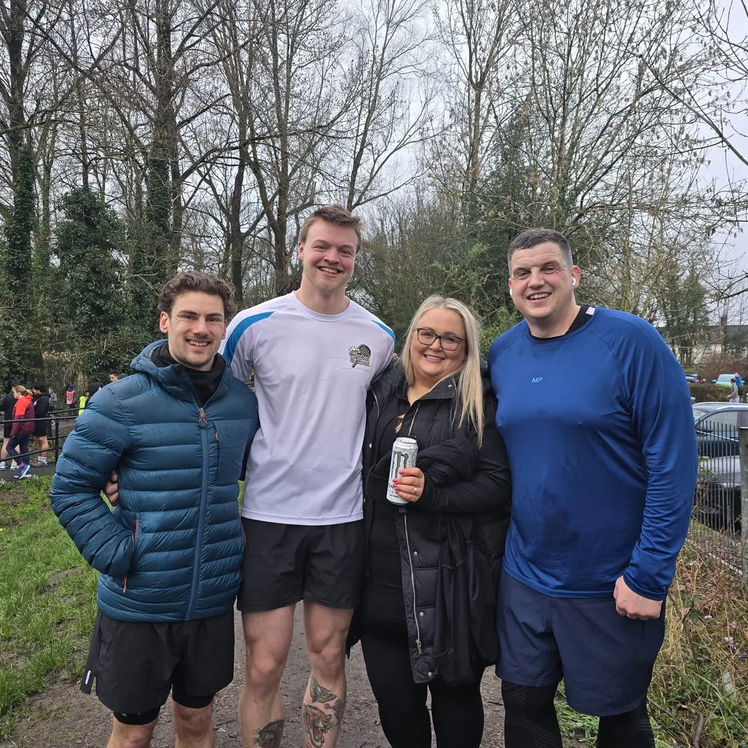 Nathan and three members arm in arm after a parkrun